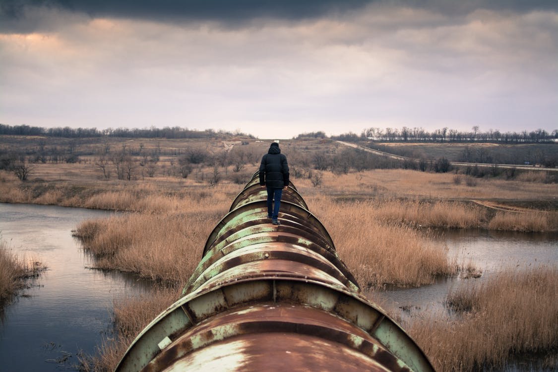 A person walking on a pipeline. Photo by: Pexels.com