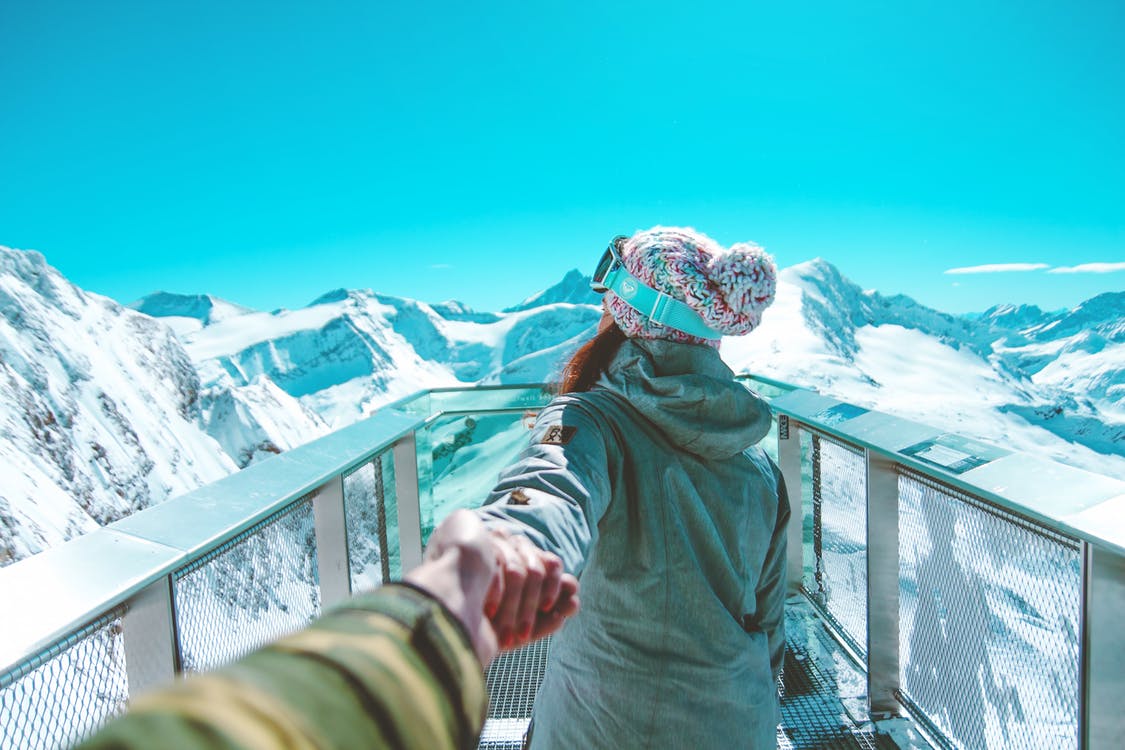 Two people taking a look over a mountain range. Photo by: Daniel Frank / Pexels.com