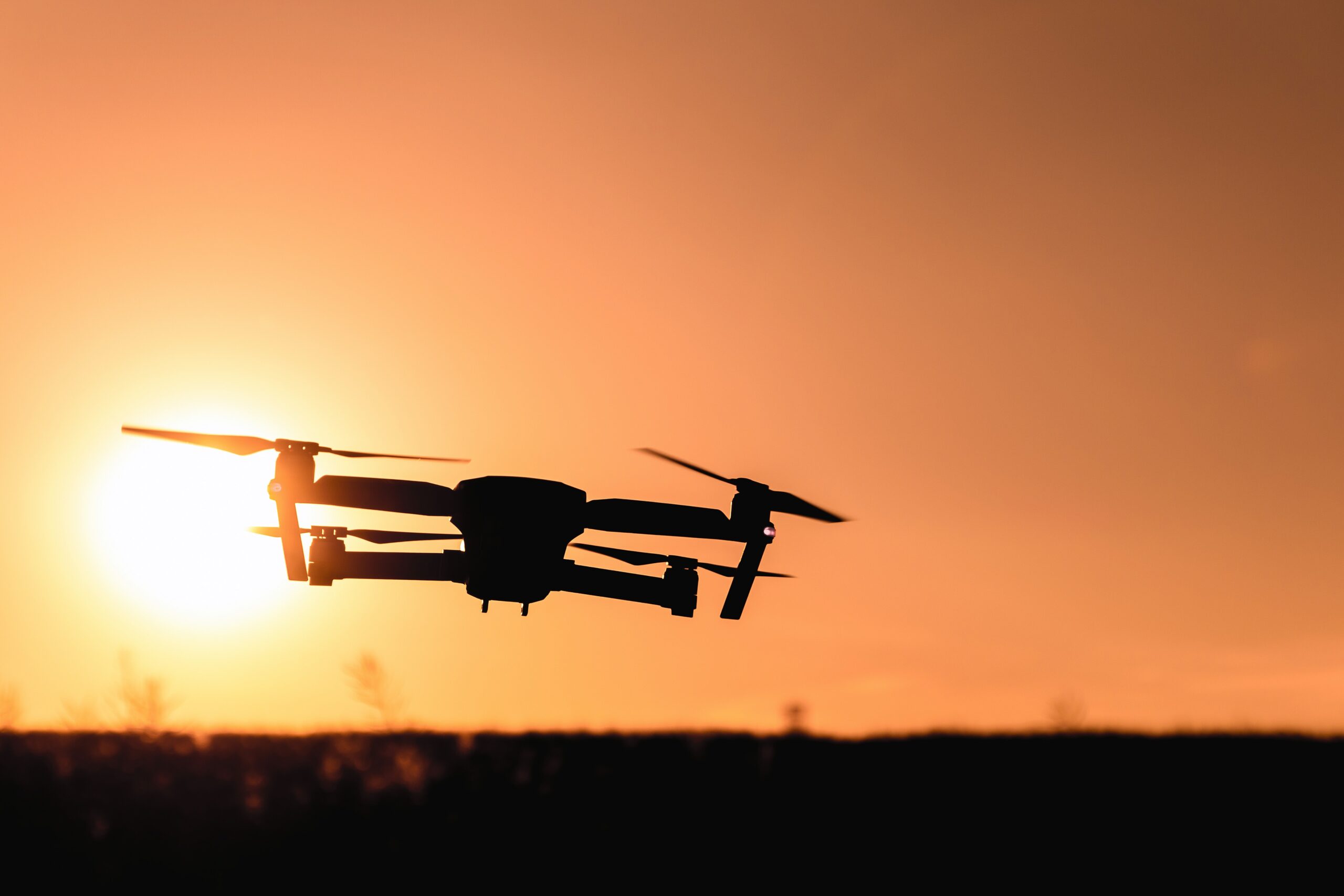 A drone flying in the sunset. Photo by JESHOOTS.com from Pexels