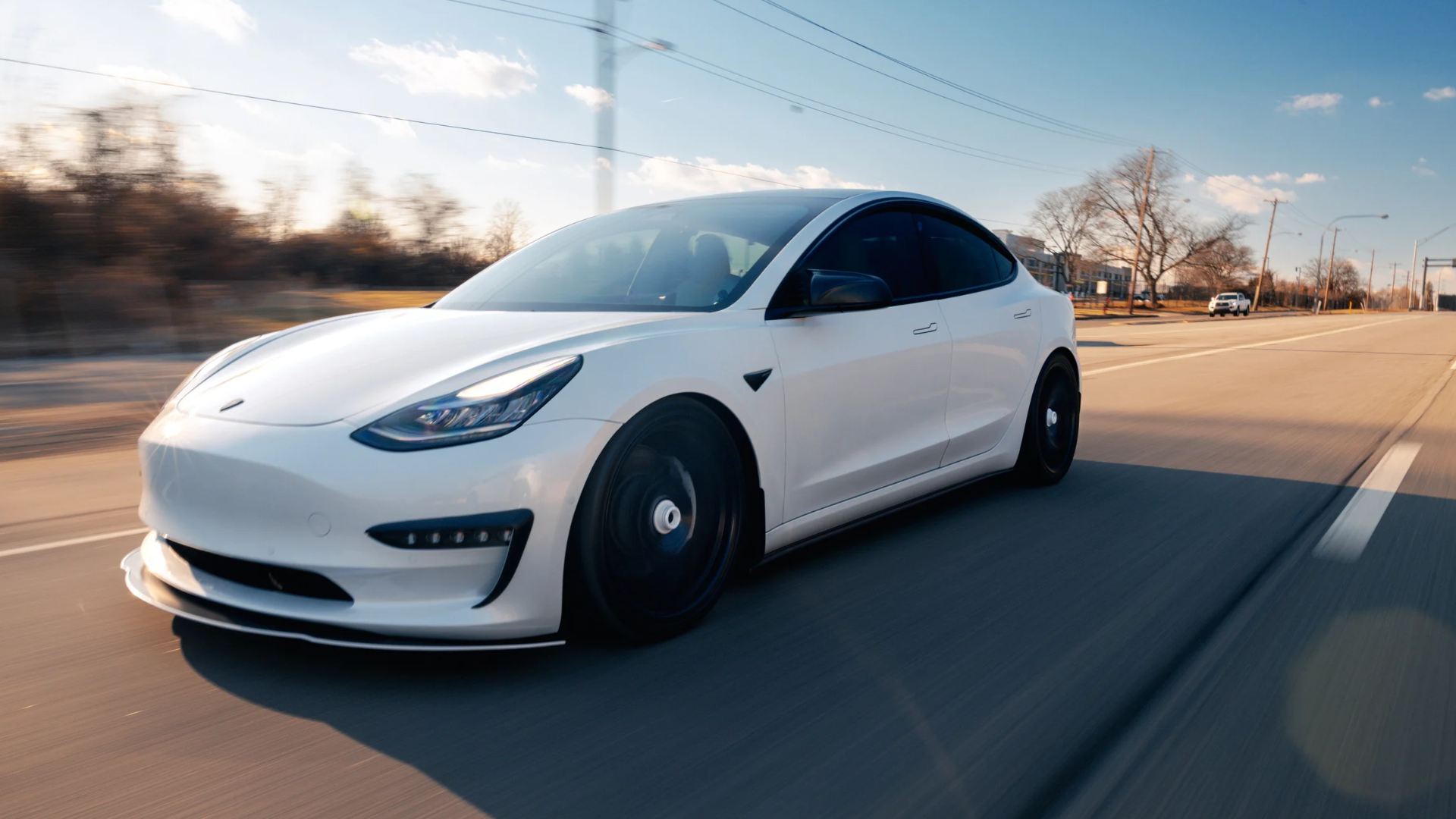A Tesla vehicle driving down the road. Photo by: Canva.com.